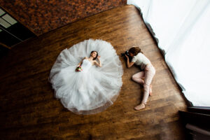 Young sexy woman photographer is taking pictures the bride in the studio